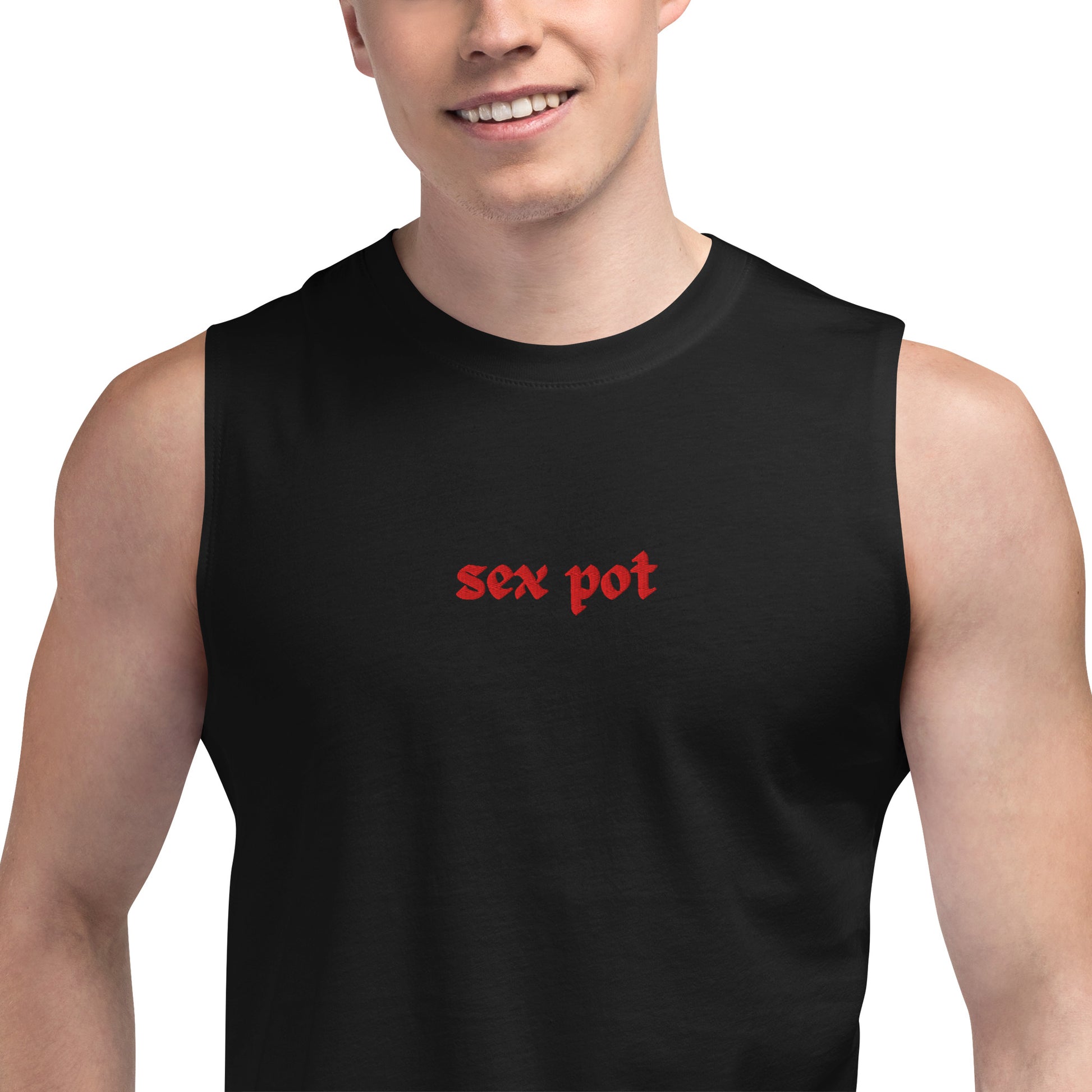 The Sex Pot Sleeveless Muscle Shirt in black with red text worn by a smiling male model