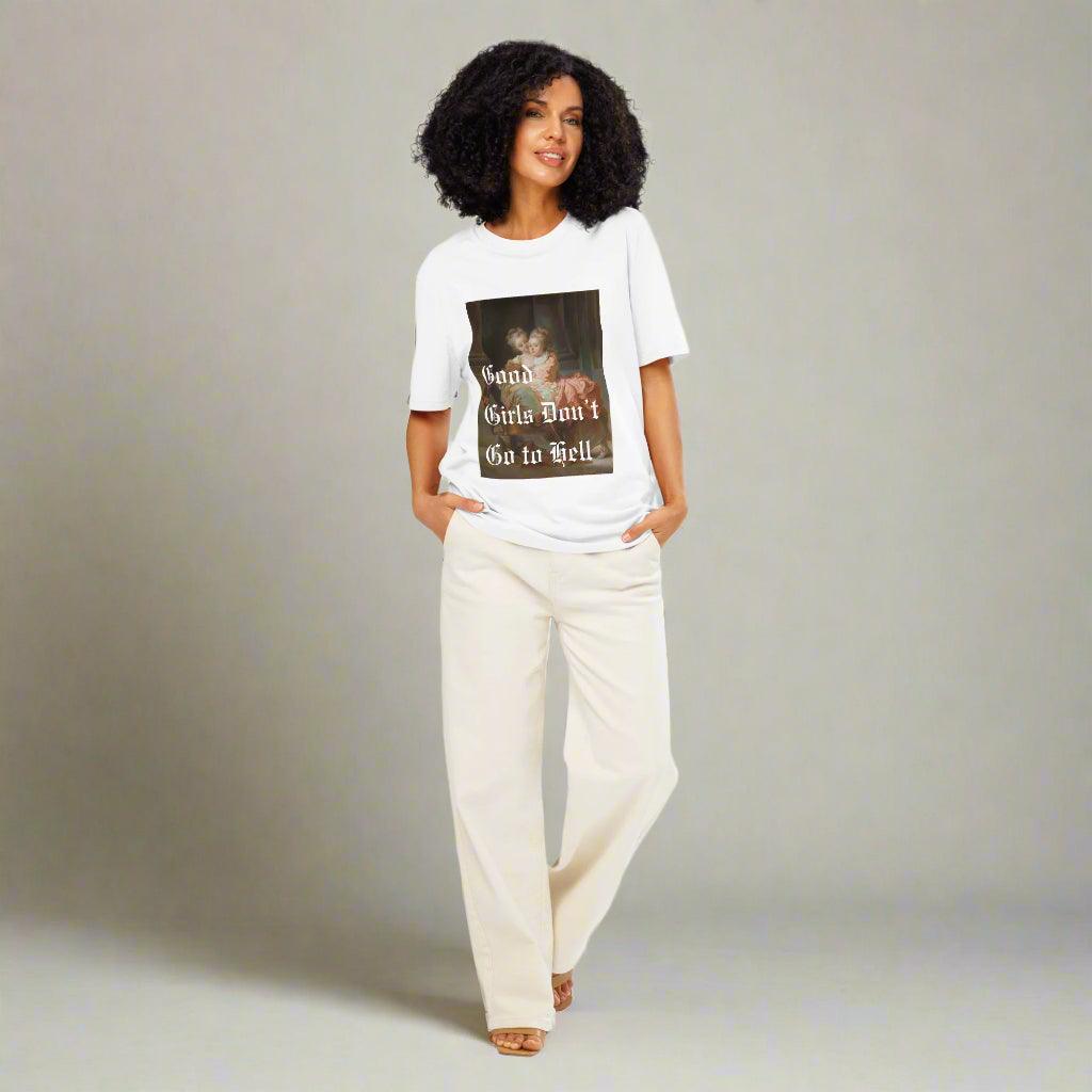 Woman wearing The Siq Collective Good Girls Don't Go To Hell Tee white graphic shirt with casual cream pants