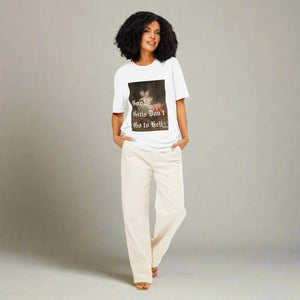 Woman wearing The Siq Collective Good Girls Don't Go To Hell Tee white graphic shirt with casual cream pants
